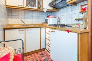 卡里索洛Le Marmotte del Brenta的厨房配有白色橱柜和台面