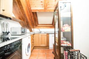 埃斯特里-德阿内乌Bonic d´Àneu的厨房配有木制橱柜、洗衣机和烘干机