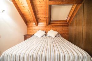 埃斯特里-德阿内乌Bonic d´Àneu的一间卧室设有一张木天花板床。