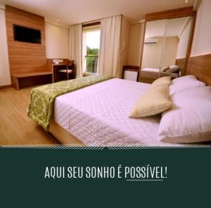 AracêCOND Vista azul hotel的一间卧室配有一张大床和一张书桌
