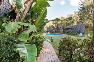 亚林加普雅林角Spa山林小屋的花园,设有砖砌的走道,毗邻游泳池