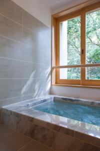 伊势市Ikyu的带浴缸的浴室和窗户