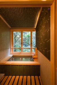 伊势市Ikyu的一个带窗户的客房内的按摩浴缸