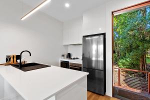马莱尼The Ridge at Maleny 1 Bedroom Villa with Spa的厨房配有黑色冰箱和窗户。
