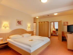 慕尼黑科瑞姆希尔德西斯嘉登酒店的卧室配有一张白色大床