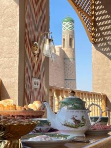 希瓦Khiva Amir Tora B&B的茶壶和一碗面包在桌子上