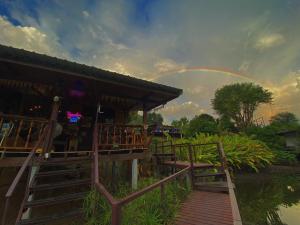Ban Tha Thong Mon班库若普度假酒店的彩虹在天空中,在一座建筑上方