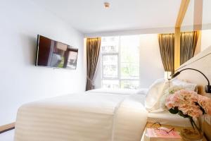 曼谷FX HOTEL NANA的卧室配有一张白色大床和电视。