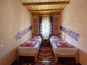希瓦Khiva Amir Tora B&B的带三张床和窗户的客房
