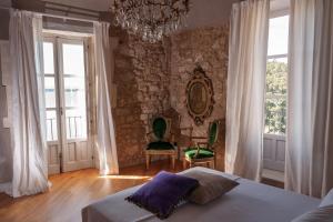 锡拉库扎Dimora Aretusa Luxury的一间卧室设有一张床和石墙