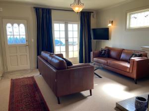 纳皮尔Beachfront Villa的客厅配有棕色皮革家具和门