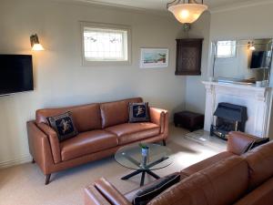 纳皮尔Beachfront Villa的客厅设有两张沙发和一个壁炉