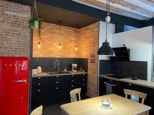 托农莱班The Loft, by So & Dam’s的厨房配有木桌和红色冰箱。