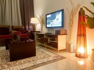 万挠Islamic Homestay Apartment Kundang, Rawang的一间客厅,配有一张桌子上放的电视