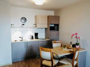 马恩河畔维列多米蒂斯蓝葡萄公寓的一间带桌椅的厨房和一间带桌子的小厨房
