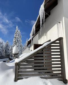 兹雷切Apartma Idila的一座有雪盖的建筑,上面挂着冰壶
