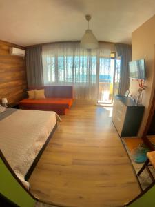帕莫瑞Sunset Yavorov Pomorie的一间卧室设有一张大床,铺有木地板