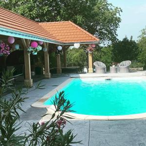 Villers-sur-PortBienvenue A La Campagne的一个带凉亭的庭院内的游泳池