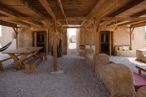 祖奇姆Desert Days mud cabin's Resort的客厅配有木桌和沙发
