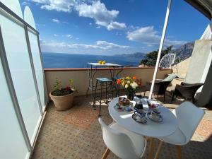 普莱伊亚诺Il Profumo dei Fiori的阳台配有桌椅,享有海景。