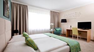 维也纳Henriette Stadthotel Vienna的酒店客房配有一张床、一张书桌和一台电视。
