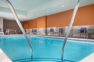 马里斯维尔La Quinta Inn & Suites by Wyndham Marysville的游泳池位于酒店客房内,配有桌椅