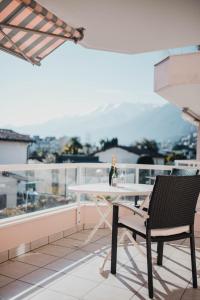 阿斯科纳Ascona: Residenza Principessa Apt. 9的阳台上的桌椅和一瓶葡萄酒