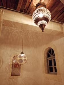 索维拉Dar Farah, riad au coeur de la médina的两个吊灯挂在天花板上