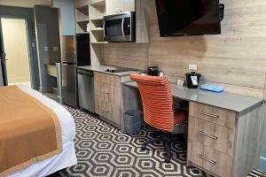 梅迪辛哈特Ramada by Wyndham Medicine Hat的客房设有带一张床和一张书桌的厨房。