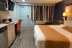 梅迪辛哈特Ramada by Wyndham Medicine Hat的酒店客房带一张床和一个厨房