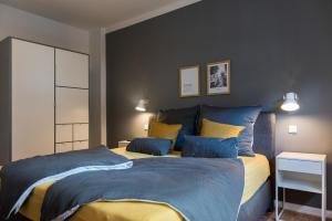 弗伦斯堡fewo1846 - flensBURG - komfortable Maisonettewohnung für 6 Personen mit Dachbalkon im 4 OG的一间卧室配有蓝色和黄色枕头的床