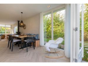 东卡佩勒Beautiful holiday home with sauna in a quiet wooded area in Oostkapelle的一间设有白色椅子和一张桌子的用餐室