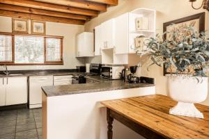 塞吉菲尔德Avemore Sedgefield的厨房配有白色橱柜和盆栽植物