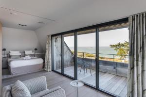 圣马洛Résidence Premium Le Bénétin- Saint Malo的一间卧室配有一张床,享有海景