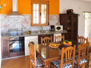弗里希利亚纳Holiday Home Tres Palmeras - FRG131 by Interhome的带餐桌的厨房和带橙色墙壁的厨房