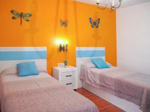 弗里希利亚纳Holiday Home La Era - FRG130 by Interhome的墙上有蝴蝶的房间的两张床