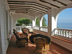 阿尔姆尼卡米莫莎阿尔穆涅卡尔别墅的一个带椅子和桌子的门廊和大海