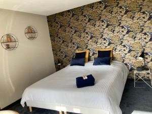 圣迪耶La Tuilerie Chambres d'Hôtes的一间卧室配有两张带蓝色枕头的床