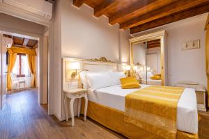 威尼斯Laguna D'oro Luxury Apartments的一间卧室配有一张带黄色毯子的大床