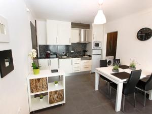 艾姆布里亚布拉瓦Apartment Port Banyuls-4 by Interhome的厨房以及带白色桌椅的用餐室。