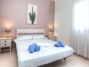 蒙特巴巴特艾古阿维拉公园1号罗雷特德马尔度假屋的卧室配有白色床和蓝色枕头