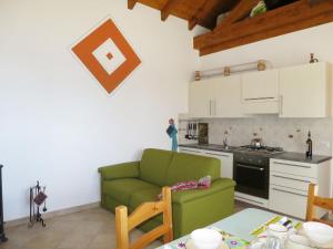 特拉雷戈Holiday Home Baita Checc by Interhome的一间带绿色沙发的客厅和一间厨房