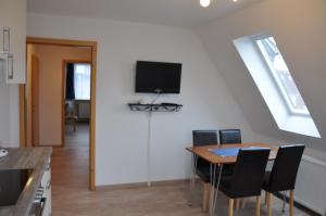 巴尔特鲁姆Ferienhaus Nordstrand Whg 4的一间设有桌子和墙上电视的用餐室