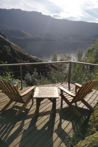 ÅkraChalet Åkrafjorden - FJH340 by Interhome的美景甲板上的野餐桌和两把椅子