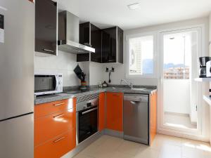 德尼亚Apartment Marina Park-1 by Interhome的厨房配有橙色和灰色的橱柜和窗户。