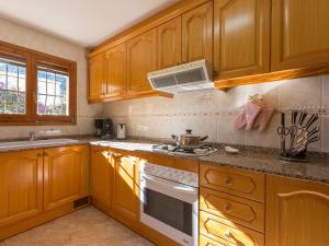 OrbaVilla Buena Gente by Interhome的厨房配有木制橱柜和炉灶烤箱。