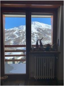 塞斯特雷Bilocale con vista a Sestriere的享有白雪 ⁇ 山景的窗户
