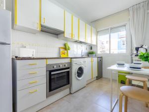 坎布里尔斯Apartment Carme by Interhome的厨房配有黄色橱柜、洗衣机和烘干机