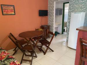 乌巴图巴Chalés Sol da Ribeira的一间带桌椅和电视的用餐室