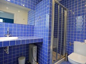 蒙特罗伊Holiday Home Marabou 2-0 by Interhome的蓝色瓷砖浴室设有卫生间和水槽